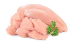 Fresh diced chicken fillet with parsley isolated on white background with clipping path and full depth of field.